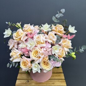 Композиция из роз, гортензий и нарциссов в шляпной коробке