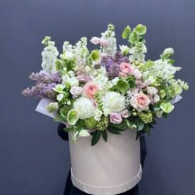 Композиция из сирени, ранункулюсов и эустомы в шляпной коробке