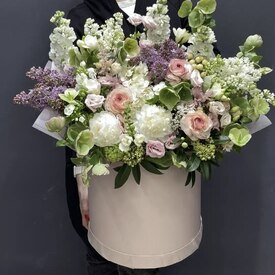Композиция из сирени, ранункулюсов и эустомы в шляпной коробке