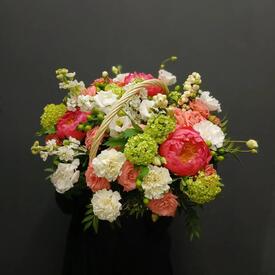 Композиция из пионов, роз и эустомы в корзине
