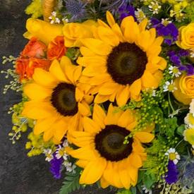 Букет из подсолнухов, кустовых роз и гербер в корзине 