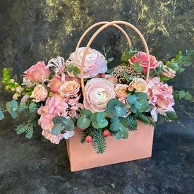 Композиция из ранункулюсов, роз и гортензий в сумке