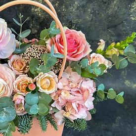 Композиция из ранункулюсов, роз и гортензий в сумке