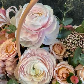 Композиция из ранункулюсов, роз и гортензий в сумке